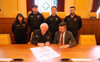 Pictured signing the scroll are Graham Price and Cllr Anthony Hunt. Standing back row left to right are Gill Calder, Pontypool RFC's Hospitality Manager, current Pontypool RFC players Callum Davies and Matt Bancroft and club Secretary Jamie Hallam