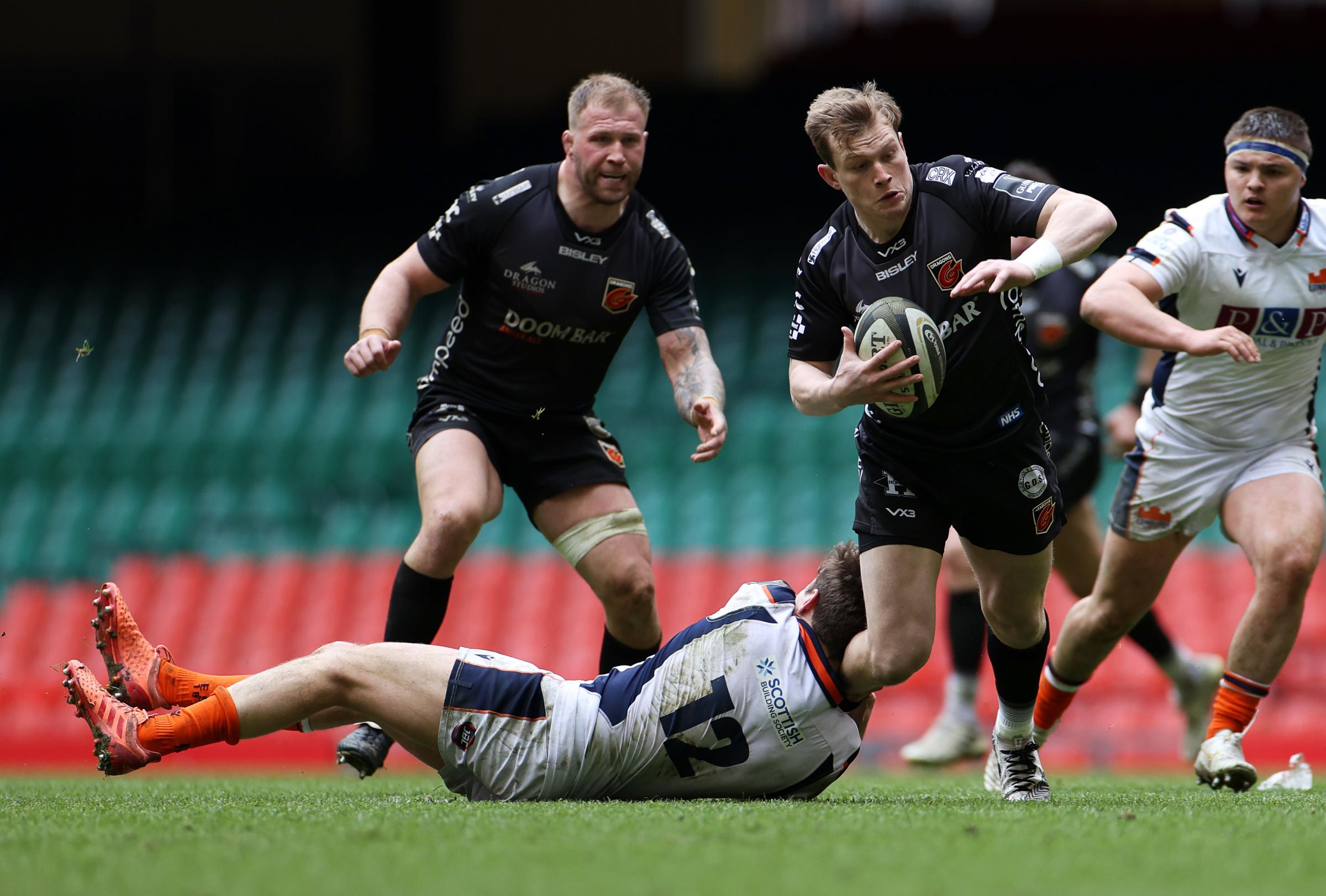 Nick Tompkins is tackled on the attack for the Dragons against Edinburgh