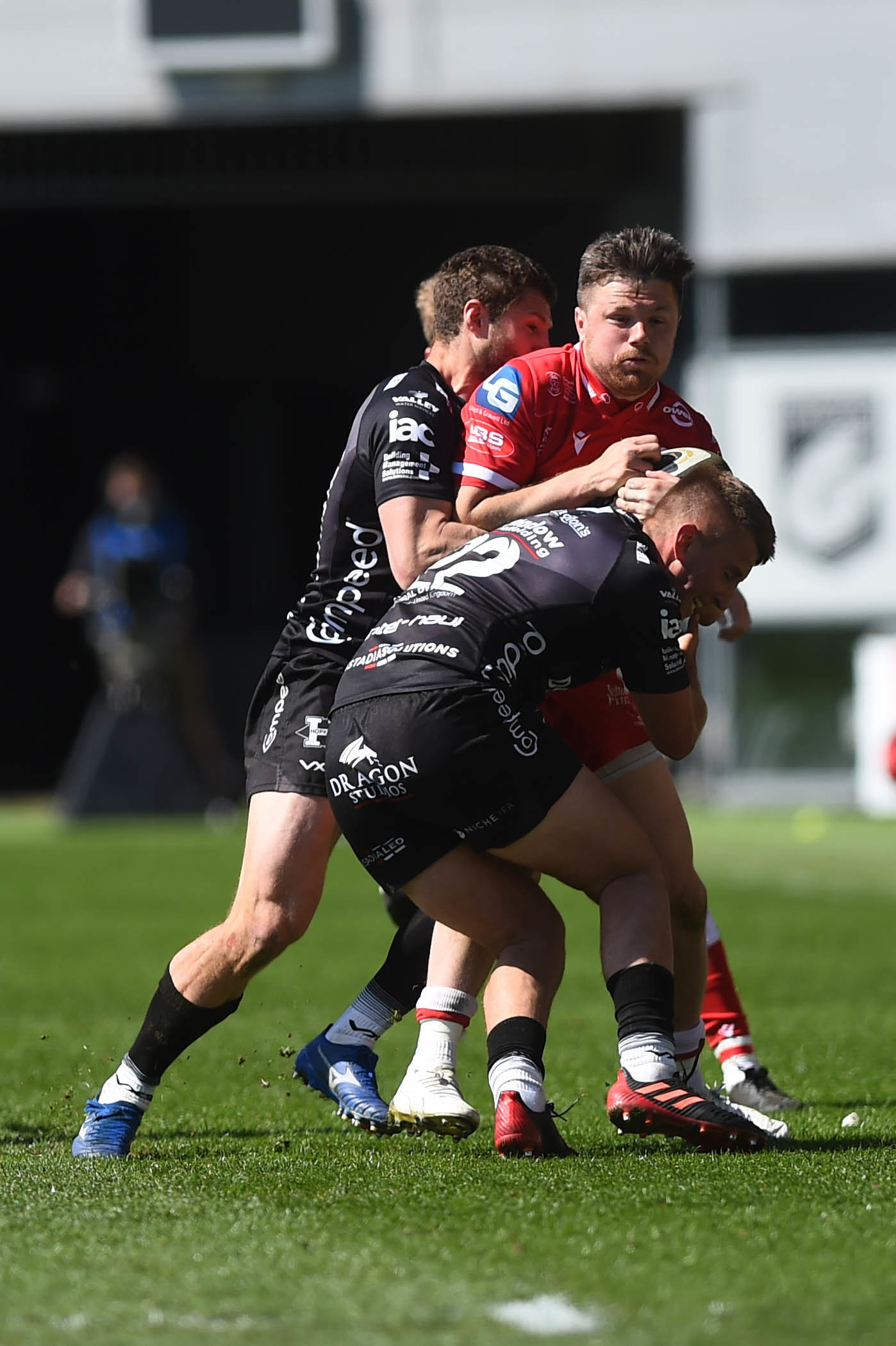 Steff Evans of Scarlets is tackled by Dan Babos of Dragons