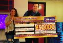 Helen Douglas receiving her winnings from Club 3000 Cwmbran manager Paul Hughes. Picture: Club 3000 Bingo.