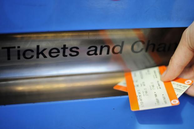 Photo shows tickets being obtained from a machine.
