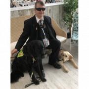 Wayne Strawford with his guide dog Alfie (L) and Laika, a guide dog puppy who he named. Picture: Guide Dogs Cymru.